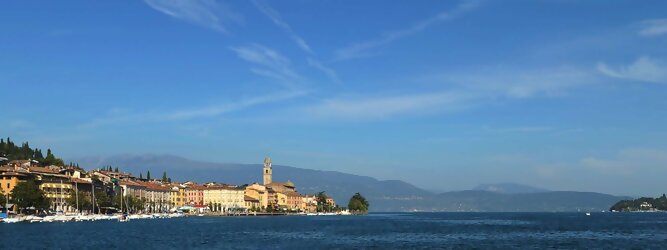 Trip Serbien beliebte Urlaubsziele am Gardasee -  Mit einer Fläche von 370 km² ist der Gardasee der größte See Italiens. Es liegt am Fuße der Alpen und erstreckt sich über drei Staaten: Lombardei, Venetien und Trentino. Die maximale Tiefe des Sees beträgt 346 m, er hat eine längliche Form und sein nördliches Ende ist sehr schmal. Dort ist der See von den Bergen der Gruppo di Baldo umgeben. Du trittst aus deinem gemütlichen Hotelzimmer und es begrüßt dich die warme italienische Sonne. Du blickst auf den atemberaubenden Gardasee, der in zahlreichen Blautönen schimmert - von tiefem Dunkelblau bis zu funkelndem Türkis. Majestätische Berge umgeben dich, während die Brise sanft deine Haut streichelt und der Duft von blühenden Zitronenbäumen deine Nase kitzelt. Du schlenderst die malerischen, engen Gassen entlang, vorbei an farbenfrohen, blumengeschmückten Häusern. Vereinzelt unterbricht das fröhliche Lachen der Einheimischen die friedvolle Stille. Du fühlst dich wie in einem Traum, der nicht enden will. Jeder Schritt führt dich zu neuen Entdeckungen und Abenteuern. Du probierst die köstliche italienische Küche mit ihren frischen Zutaten und verführerischen Aromen. Die Sonne geht langsam unter und taucht den Himmel in ein leuchtendes Orange-rot - ein spektakulärer Anblick.